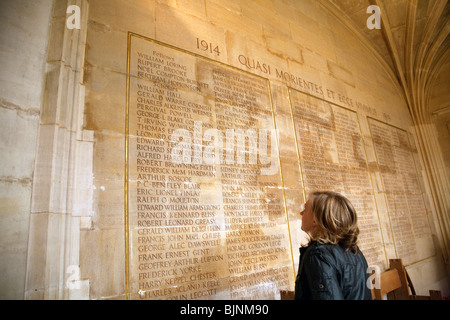 Ein Tourist auf der Suche auf die Namen der Toten im ersten Weltkrieg, darunter der Dichter Rupert Brooke, Kings College Chapel, Cambridge UK Stockfoto