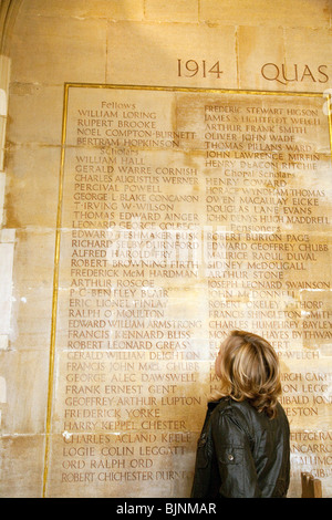 Ein Tourist auf der Suche auf die Namen der Toten im 1. Weltkrieg, darunter der Dichter Rupert Brooke, Kings College Chapel, Cambridge UK Stockfoto