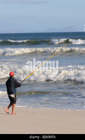 Mann Angeln vom Strand von Muizenberg in der western Cape-Südafrika Stockfoto