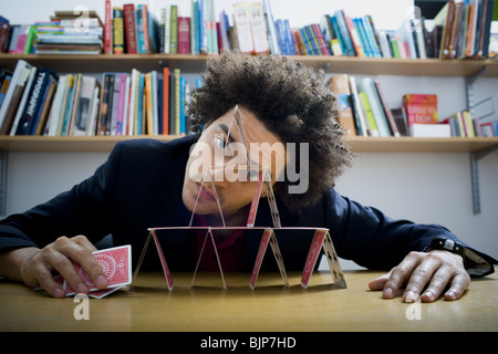 Mann, der eine Pyramide aus Spielkarten Stockfoto