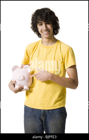 Junge hält ein Sparschwein Stockfoto