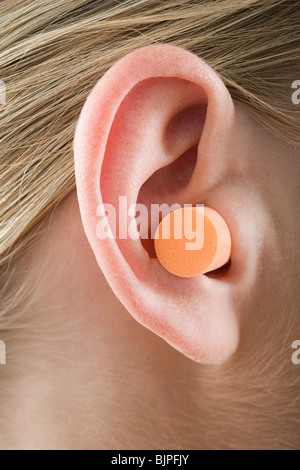 Eine Frau trägt einen Ohr-Stecker Stockfoto