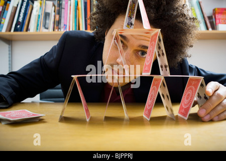 Mann, der eine Pyramide aus Spielkarten Stockfoto