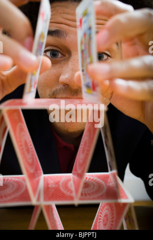 Mann, der eine Pyramide aus Spielkarten Stockfoto