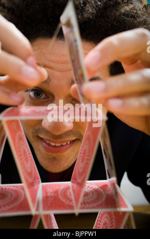 Mann, der eine Pyramide aus Spielkarten Stockfoto