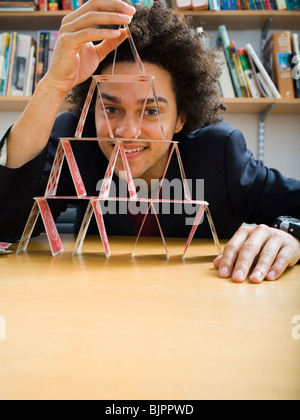 Mann, der eine Pyramide aus Spielkarten Stockfoto