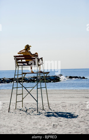 Mann sitzt im Stuhl Rettungsschwimmer am Strand Stockfoto