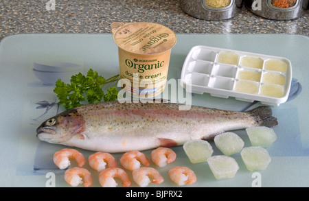 Kochen mit Wein. Übrig gebliebene Wein als Eiswürfel gefroren, mit Sahne als Soße Zutaten mit Regenbogenforellen und Garnelen und mit Petersilie garnieren zu gehen Stockfoto