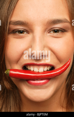 Frau beißt in ein Pfeffer Stockfoto