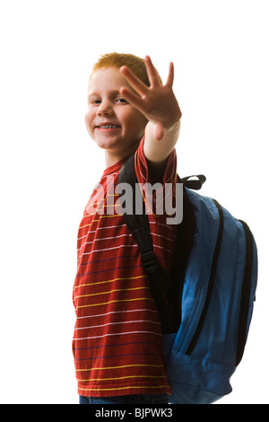 Junge winkt mit Schulbus im Hintergrund Stockfoto