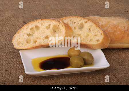 Olivenöl und Balsamico-Essig verwendet als Dip mit Brot und mit großen Oliven als Beilage Stockfoto