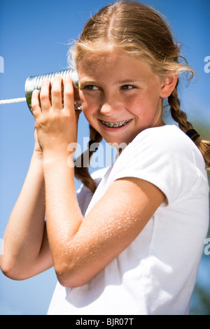 Kleine Mädchen spielen mit Blechdose Telefon Stockfoto