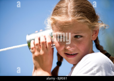 Kleine Mädchen spielen mit Blechdose Telefon Stockfoto