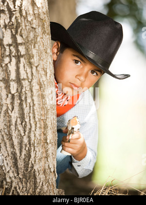 Junge im Cowboy-Kostüm mit Spielzeugpistole Stockfoto