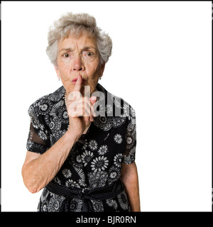 Ältere Frau shushing Kamera. Stockfoto