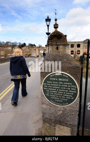 Eine Frau geht über die Stadtbrücke in Bradford on Avon aus dem 13. Jahrhundert und verdoppelte sich im Jahr 1769 Stockfoto