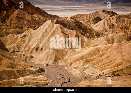 Wanderer in den Badlands am Zabriskie Point mit Blick auf Golden Canyon in Death Valley Nationalpark, Kalifornien, USA. Stockfoto