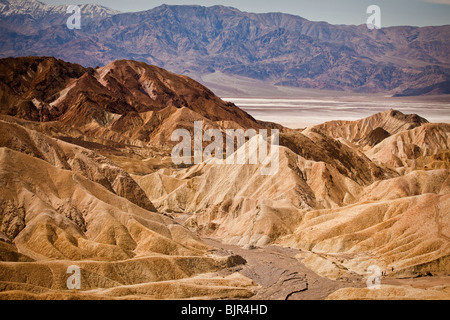 Wanderer in den Badlands am Zabriskie Point mit Blick auf Golden Canyon in Death Valley Nationalpark, Kalifornien, USA. Stockfoto