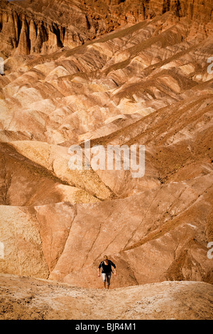 Wanderer in den Badlands am Zabriskie Point mit Blick auf Golden Canyon in Death Valley Nationalpark, Kalifornien, USA. Stockfoto