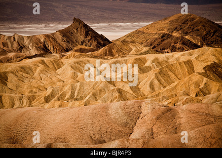 Wanderer in den Badlands am Zabriskie Point mit Blick auf Golden Canyon in Death Valley Nationalpark, Kalifornien, USA. Stockfoto