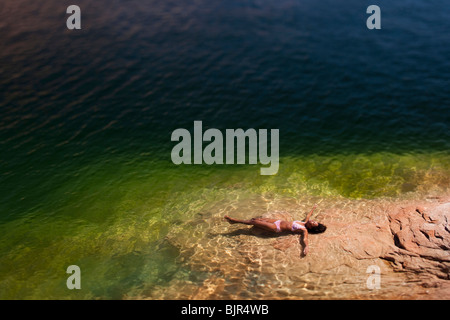 Frau im Wasser auf Rücken liegend Stockfoto
