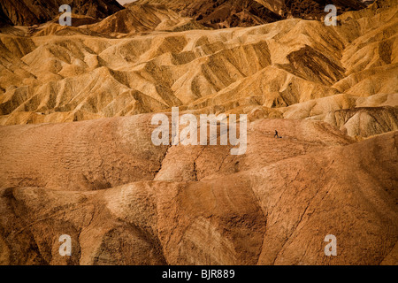 Wanderer in den Badlands am Zabriskie Point mit Blick auf Golden Canyon in Death Valley Nationalpark, Kalifornien, USA. Stockfoto