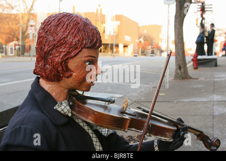 Junge Schaufensterpuppe Geige zu spielen. Dickens viktorianische Dorf Szene Anzeige in Cambridge, Ohio, USA. Stockfoto