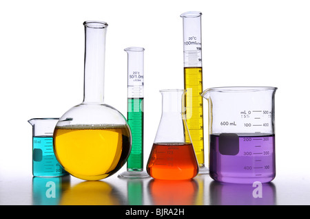 Laborglas mit Flüssigkeiten in verschiedenen Farben auf weißem Hintergrund Stockfoto