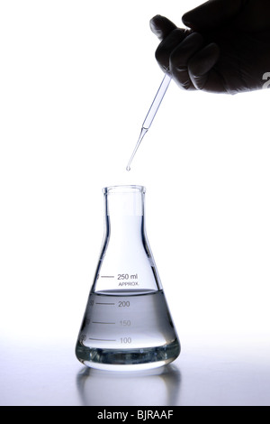 Laborantin tragen Latex-Handschuh mit Pipette Flüssigkeit in Flasche fallen zu lassen Stockfoto