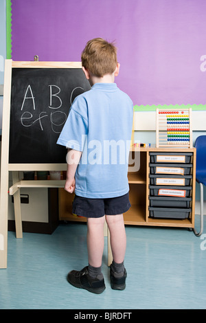 Junge auf Tafel schreiben Stockfoto