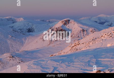 Alpenglühen auf dem Schnee bedeckt große Giebel von Scafell im Lake District National Park im Nordwesten Englands gesehen Stockfoto