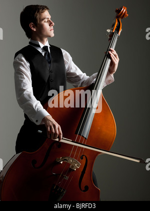 Junger Mann spielt Kontrabass, Studio gedreht Stockfoto