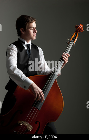 Junger Mann spielt Kontrabass, Studio gedreht Stockfoto