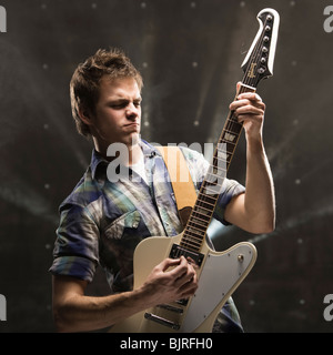 Junger Mann spielt Bassgitarre, Studio gedreht Stockfoto