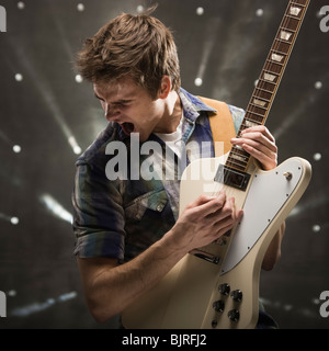 Junger Mann spielt Bassgitarre, Studio gedreht Stockfoto