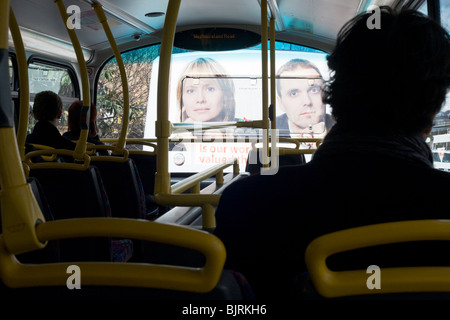 Bus Fahrgäste Gesicht nach vorn zu sehen, große stecken Flächen auf der Rückseite eines anderen Fahrzeugs, Werbung auch im Stau. Stockfoto