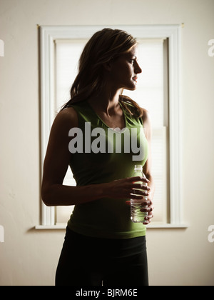 USA, Utah. Orem, junge Frau stehen und halten Wasser Flasche Stockfoto