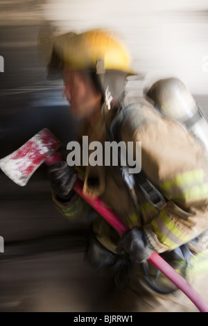 Männlichen Feuerwehrmann in Aktion Stockfoto