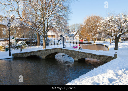 Eine Schlittenfahrt im Winter Schnee in der Cotswold-Dorf Bourton auf dem Wasser, Gloucestershire Stockfoto