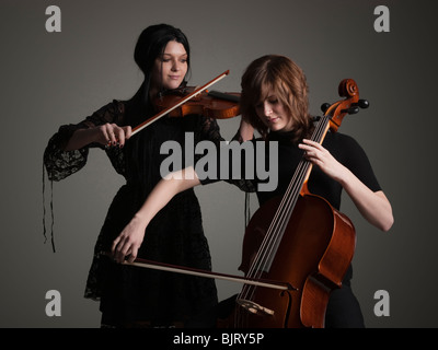 Zwei junge Frauen, die Saiteninstrumente spielen Stockfoto