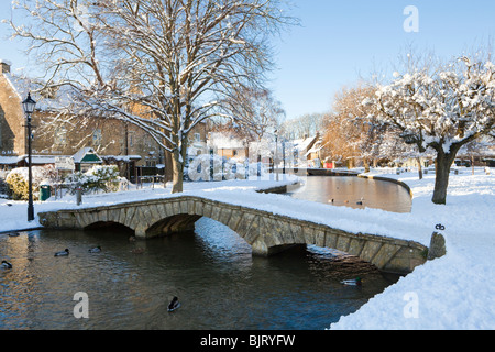 Winterschnee auf einer der Brücken über den Fluss Windrush im Cotswold Dorf Bourton on the Water, Gloucestershire UK Stockfoto