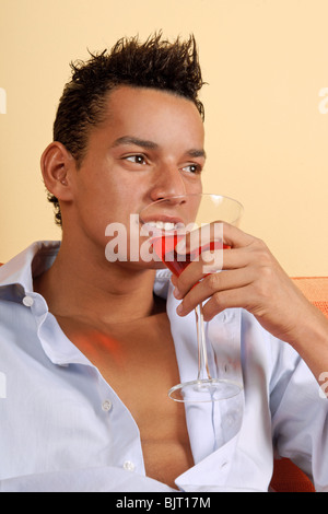 Porträt eines lächelnden jungen Latin hält einen roten cocktail Stockfoto