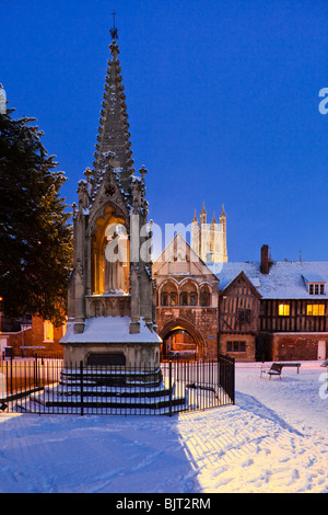 Dämmerung fallen im Winterschnee am Bischof Hooper-Denkmal in St. Mary Square neben der Kathedrale von Gloucester Stockfoto