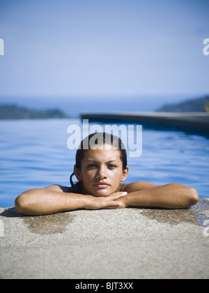 Frau ruht auf Felsvorsprung Swimming Pool Stockfoto