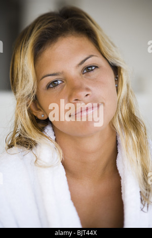 Frau im Morgenmantel sitzt auf einem Bett Stockfoto