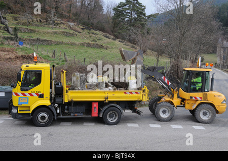 Alten Kilometer Roadstone Marker wird aufgerissen und in einen LKW geladen und entfernt. Diese Zeichen sind französische Symbole verschwinden. Stockfoto