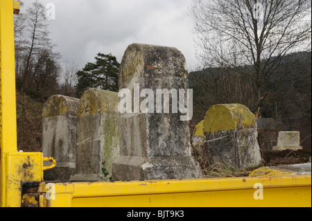 Alten Kilometer Roadstone Marker wird aufgerissen und in einen LKW geladen und entfernt. Diese Zeichen sind französische Symbole verschwinden. Stockfoto