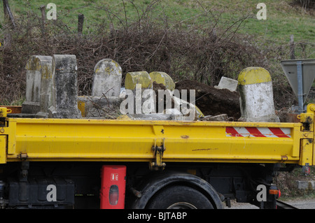 Alten Kilometer Roadstone Marker wird aufgerissen und in einen LKW geladen und entfernt. Diese Zeichen sind französische Symbole verschwinden. Stockfoto