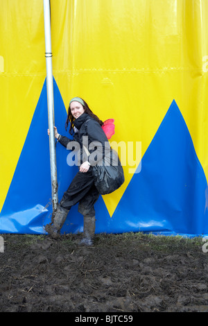 Glastafarian wischt Schlamm aus ihren Stiefeln auf einem Festzelt Mast im Bereich Zirkus und theater Stockfoto