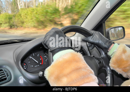 Eine Nahaufnahme von einer Frau die Hand am Lenkrad eines Autos. Sie trägt treibende Lederhandschuhe. Stockfoto